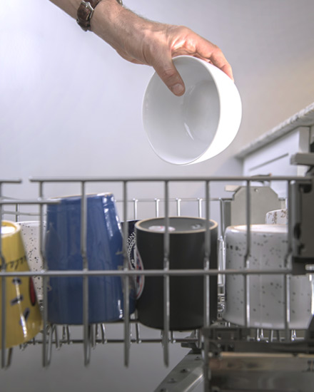 Dishes being loaded into a dishwasher