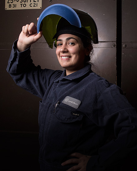 A Con Edison employee lifting a protective face-visor.