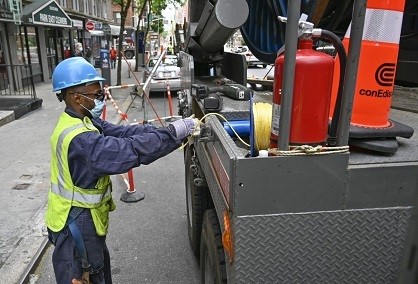 Un trabajador de servicios públicos tira un cable desde la parte trasera de un camión.