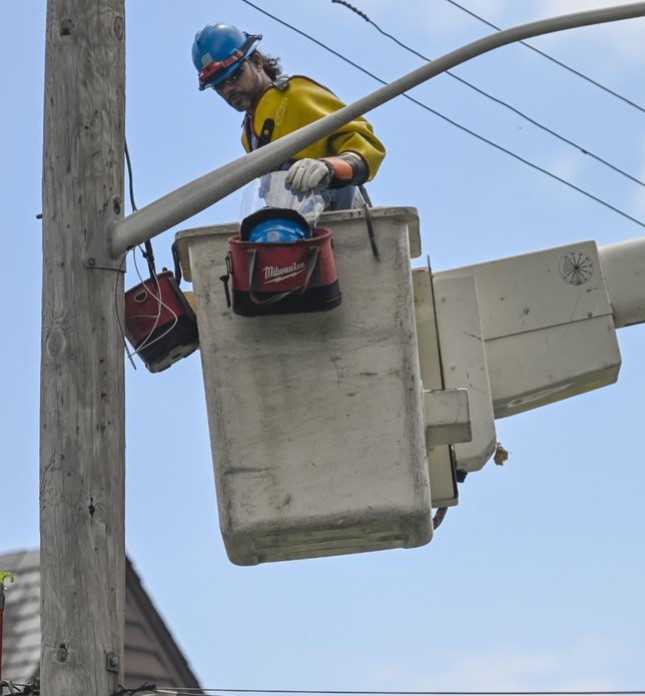 A worker in a bucket truck repairs a utility pole.
