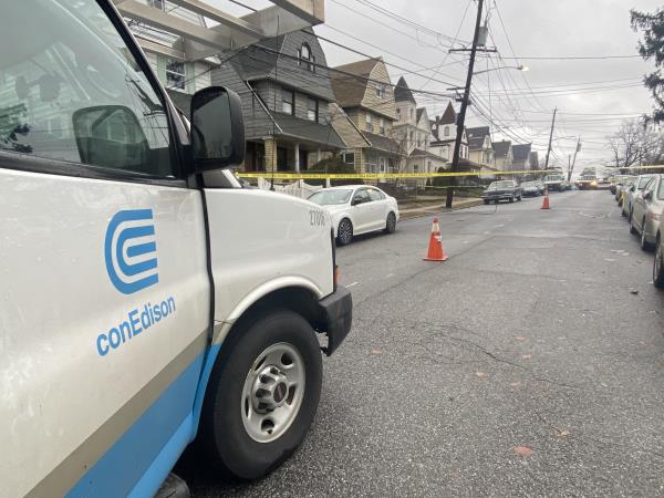 A Con Edison truck parked near an area marked with emergency tape. 