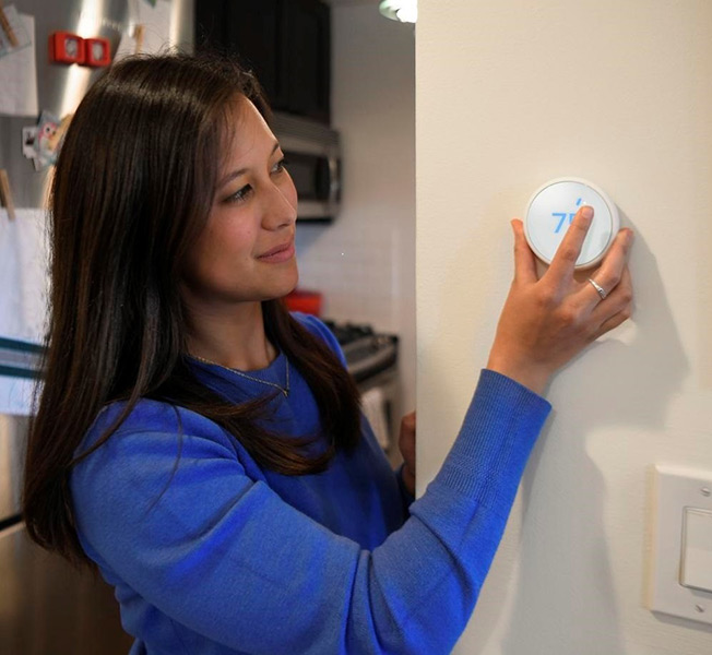 Una mujer regulando un termostato.