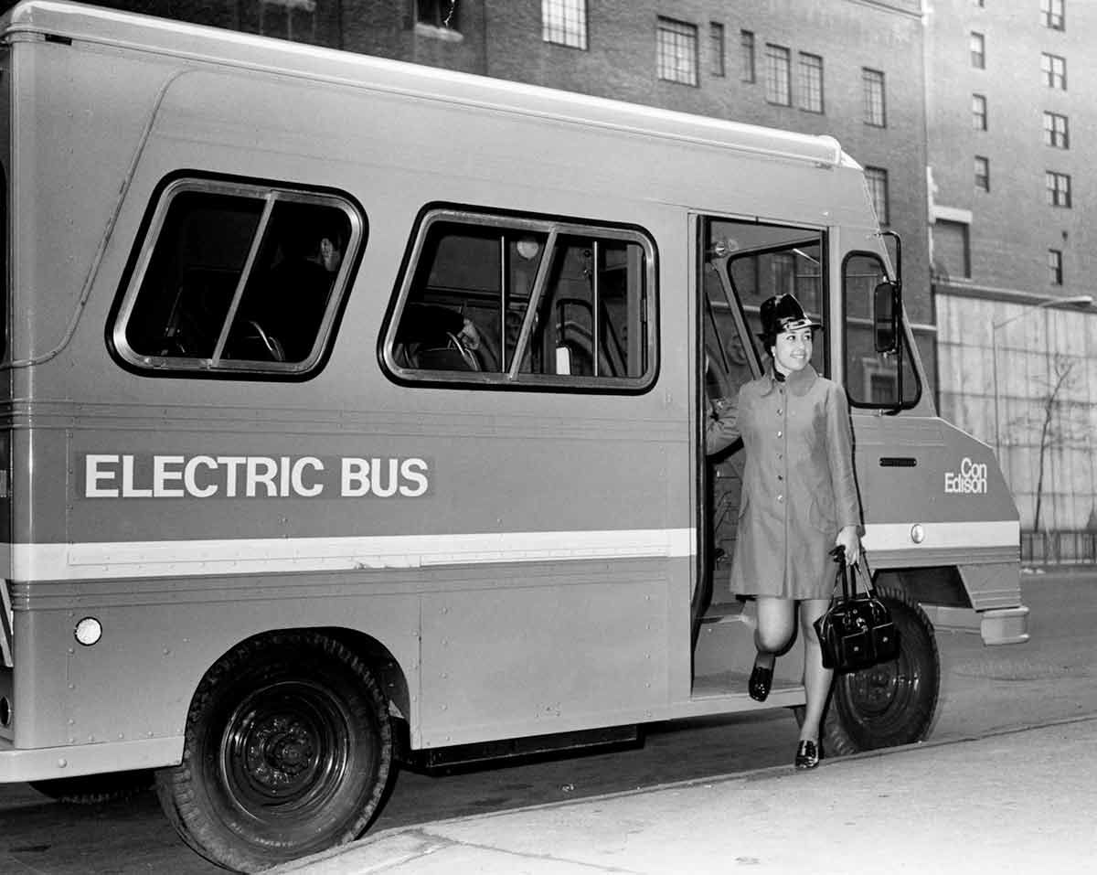 Black and white photo of a woman disembarking off from a Con Edison bus