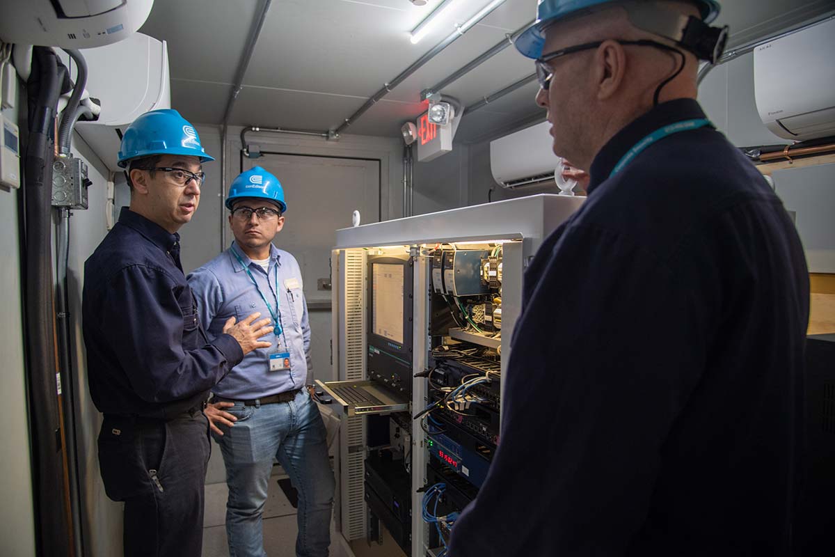 Tres trabajadores de Con Edison inspeccionando un sistema de almacenamiento de baterías.