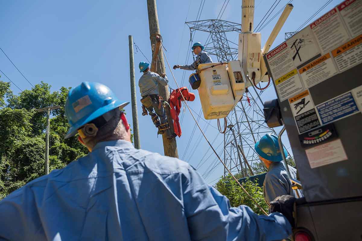 Trabajadores de Con Edison recibiendo capacitación sobre equipos de emergencia aéreos en postes para servicios públicos.
