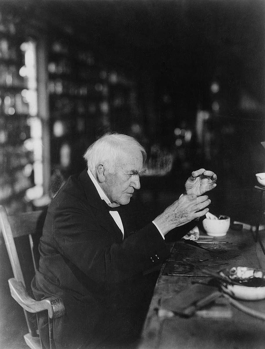 Black and white photo of Thomas Edison working in his laboratory.