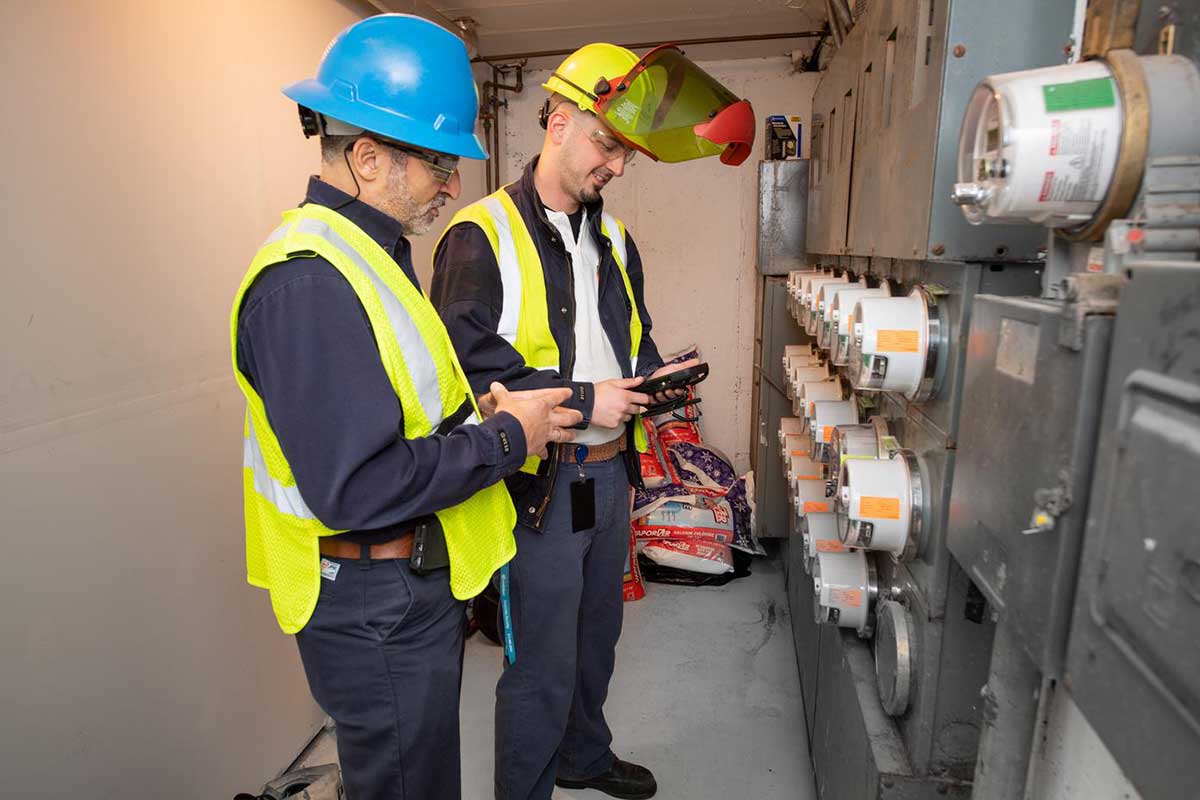 Dos trabajadores de Con Edison instalan un medidor AMI en Staten Island.