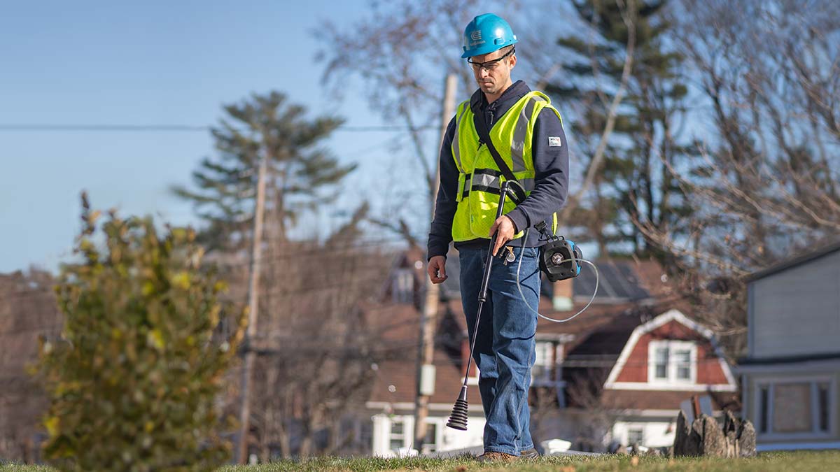 A Con Edison leak survey technician performs a walking survey of residential gas service.