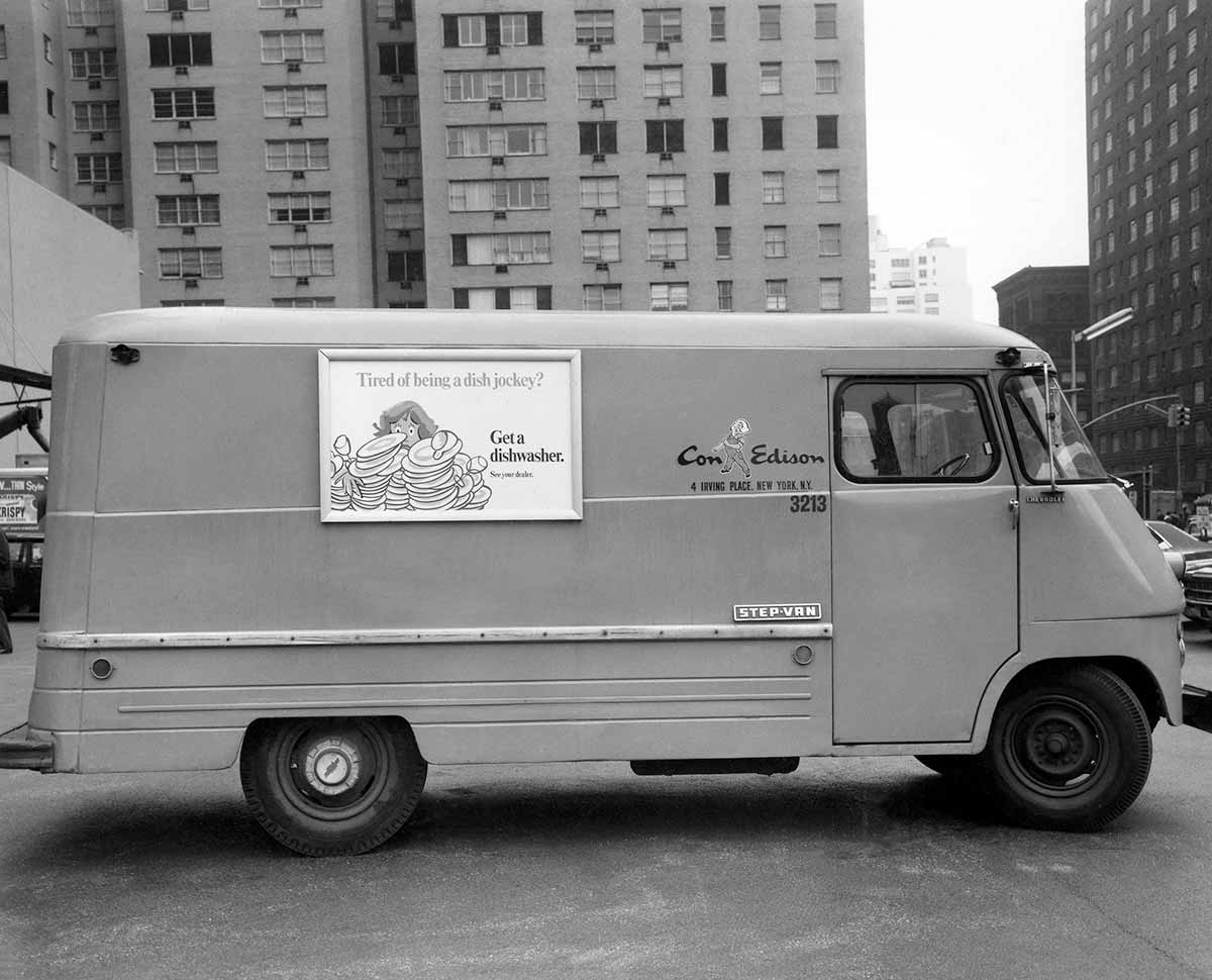 Black and white photo of a Con Eison work van driving on the streets of New York City.
