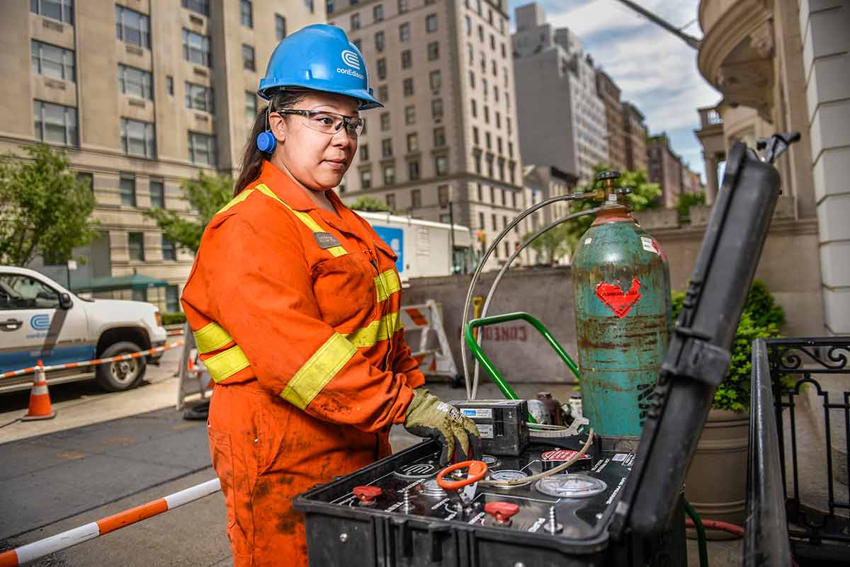 A Con Edison employee working at a gas replacement site on a New York City street.