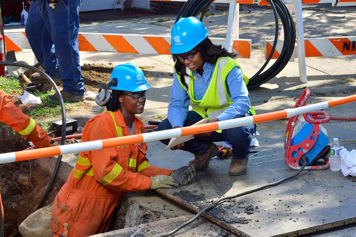 Con Edison employees reviewing schematics at a worksite.