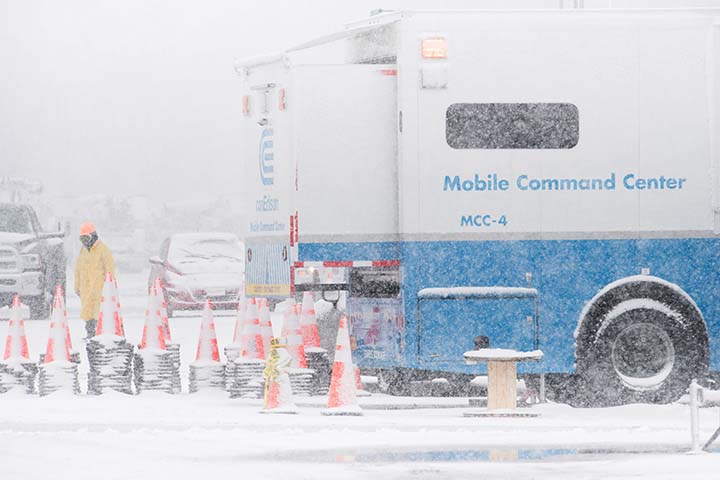 Un camión utilitario y un trabajador en una tormenta de nieve.