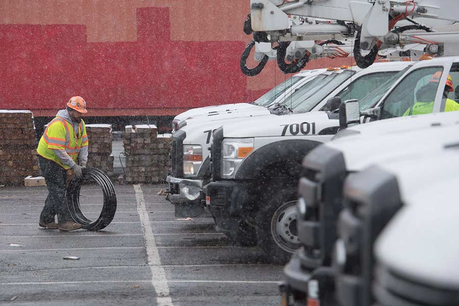 Un empleado de Con Edison traslada suministros a un camión, como parte de las labores de restauración de Riley-Quinn. 