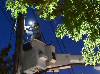 Un trabajador en un camión grúa repara cables aéreos.
