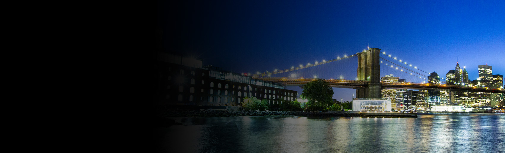 Una vista nocturna del puente de Brooklyn y el East River.
