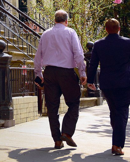 Two men walking down a sidewalk.