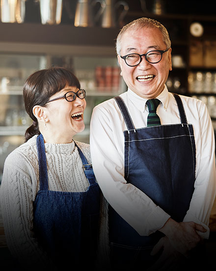 Woman and man standing in their shop laughing with each other