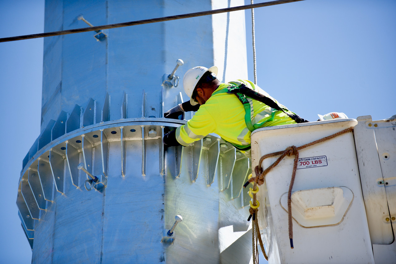 A worker in a bucket truck building an electrical system.